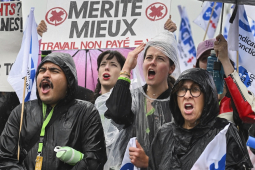 Six picketers hold signs in the rain, including, “Ground our rights? Ground the planes!”