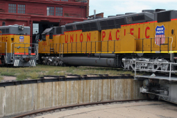 An orange Union Pacific railroad locomotive is shown in a repair area.