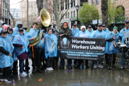 Los trabajadores de Bergen Logistics y sus simpatizantes se reúnen con ponchos de lluvia azules.