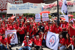 Una gran multitud de miembros de SINTTIA con camisetas rojas sostienen pancartas celebrando el Primero de Mayo.