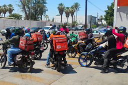 Workers stand by on their motorcycles. 