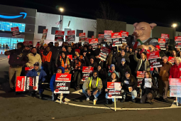Workers gather holding signs reading: Just Practicing for Safe Jobs, and Just Practicing for Dignity and Respect.