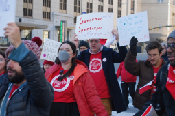 A crowd marches with signs