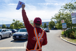 A worker holds a flyer in the air. His hat reads: "Vote Unifor"