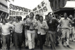 Black and white photo of men marching with a banner: "SUPPORT BLF GREEN BANS"