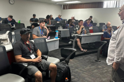 Richard, a white man with a mustache and glasses, speaks to attentive labor school participants seated in a classroom.