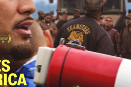 Close-up of a man's chin with bullhorn and the back of someone's Teamsters jacket in a crowd. Overlaid in yellow type is the movie title: Who Moves America.