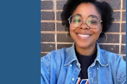 A smiling Black woman in round glasses and a jean jacket is shown