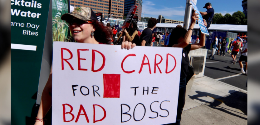 A worker holding a sign that says: Red card for the bad boss