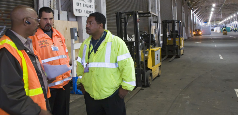 Three workers discussing workplace issues.
