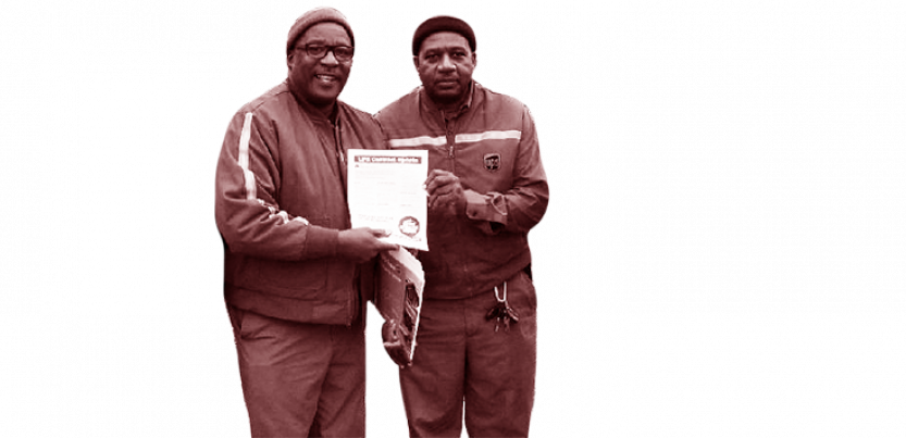 Two UPS workers holding a document.