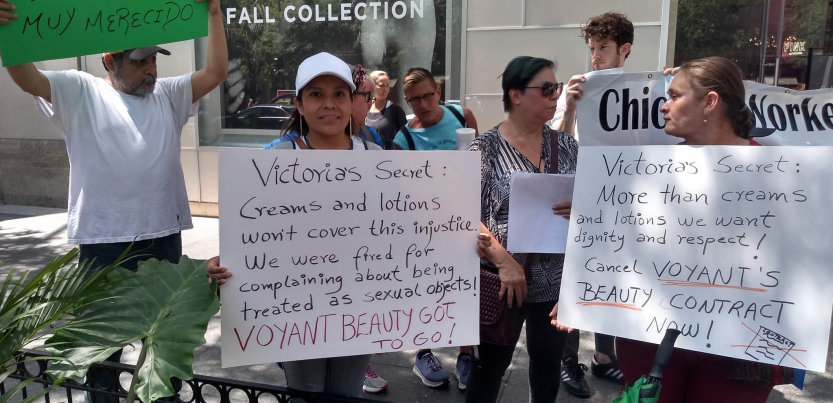 Voyant Beauty workers demonstrate in front of a Victoria's Secret store in Chicago, holding signs that read: "Victoria's Secret: Creams and lotions won't cover this injustice. We were fired for complaining about being treated as sexual objects! Voyant Beauty has got to go!" and "Victoria's Secret: More than creams and lotions we want dignity and respect! Cancel Voyant Beauty's contract now!"