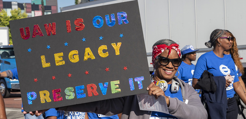 Woman auto worker holding up sign