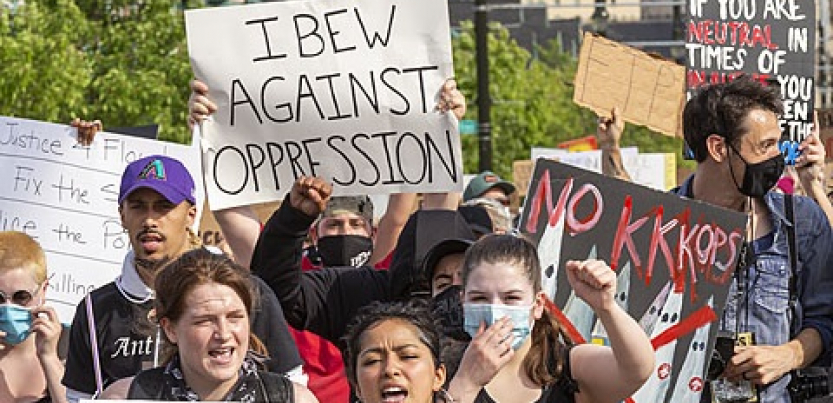 Marchers with signs including "IBEW Against Oppression" and "No KKKops"