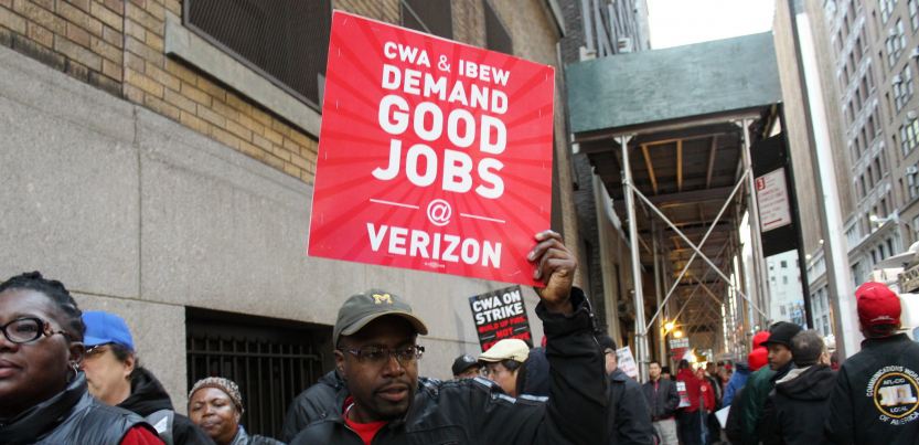 A striking worker holds a sign saying "CWA and IBEW Demand Good Jobs at Verizon" during the 2016 Verizon strike.