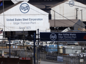 Two large white barn-shaped buildings with the U.S. Steel logo are shown.