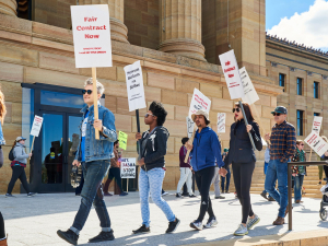 Strikers and supporters march with picket signs in front of the Philadelphia Museum of Art.