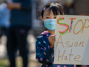 Little girl holding sign reading "Stop Asian Hate."