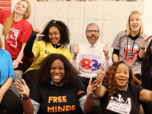 Eight teacher leaders from the Unions We Deserve slate pose together, smiling and giving thumbs-up. T-shirt slogans include "flree minds," "Black lives matter at school," "Baltimore schools for Baltimore students," and "build one Baltimore"