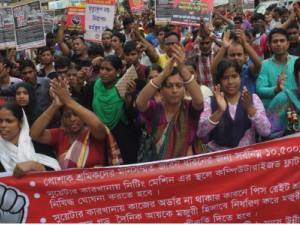 Bangladeshi workers rally behind a banner