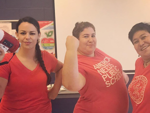 Three Chicago teachers, one with bullhorn and two with arms flexed.