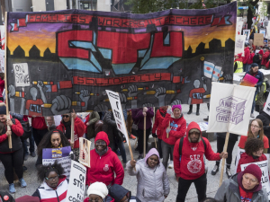 Dozens of strikers stand around a Chicago Teachers Union banner.