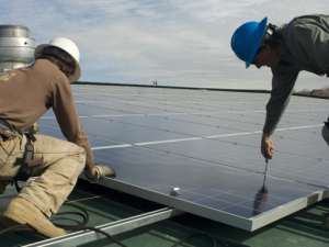 Two workers installing solar energy at Garfield County Fairgrounds