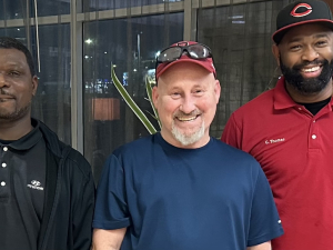 Three smiling men, two African American, one European American, face the camera