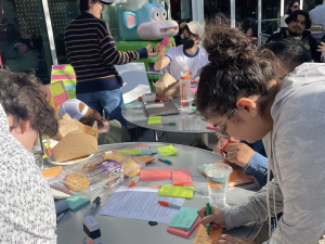 A group write colorful post-in at outside round tables--one says bereavement leave