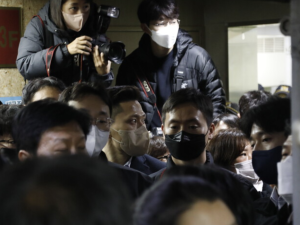 People and photographers gather at KCTU headquarters during the raid.