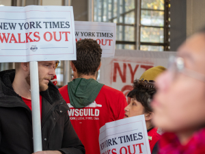 picketers outside New York Times headquarters with a jumble of NewsGuild signs.