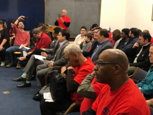 Meeting of DASH drivers, most of them seated and wearing red.