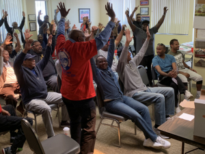 Strike authorization vote - people standing with arms raised.