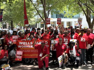 A large group wearing red with banners and signs and flags pose for the camera