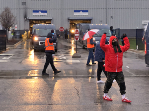 Amazon workers picketing in the parking lot of their warehouse.