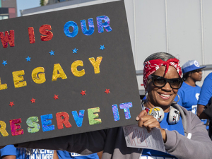 Woman auto worker holding up sign