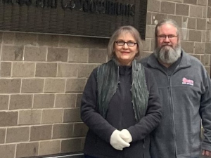 A couple stand by a wall with a Hyatt sign