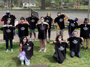 Duke University Press Workers Union posing in matching black T-shirts on grass.