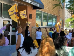 Workers with flags gather outside the glass-doored offices of Frontline in Cleveland