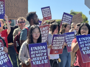 Students and faculty members rally holding signs that say "Union Busting Is Not a Jesuit Value" and "LMU: Back to the Table Now."