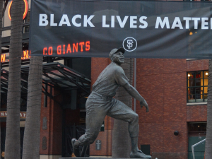 A Black Lives Matter banner hangs behind a statue of Willie Mays at Oracle Park.