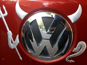 Devil horns, pitchfork, and tail have been added to the VW logo on a car