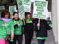 Four women carrying picket signs for AFSCME 3299 strike