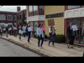 A group of teachers marches on the sidewalk in downtown Andover, Massachusetts.