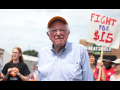Photo of Bernie Sanders in front of Fight for $15 sign.