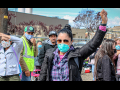 Woman with fist up amidst farmworkers on strike