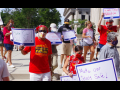 Teachers wearing masks hold signs that say Make Our Schools Safe and Not Until It's Safe.