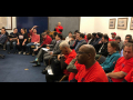 Meeting of DASH drivers, most of them seated and wearing red.