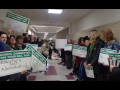 Brookline paraeducators with signs lining hallway of school.