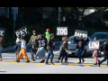 grad students blocking traffic in the street with signs that read "The Pay Is Too Damn Low"